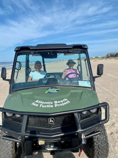 UTV on the beach with Atlantic Beach Sea Turtle Project decals on the hood.