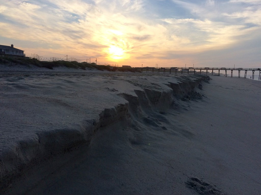 A steep escarpment near the shoreline of the beach.